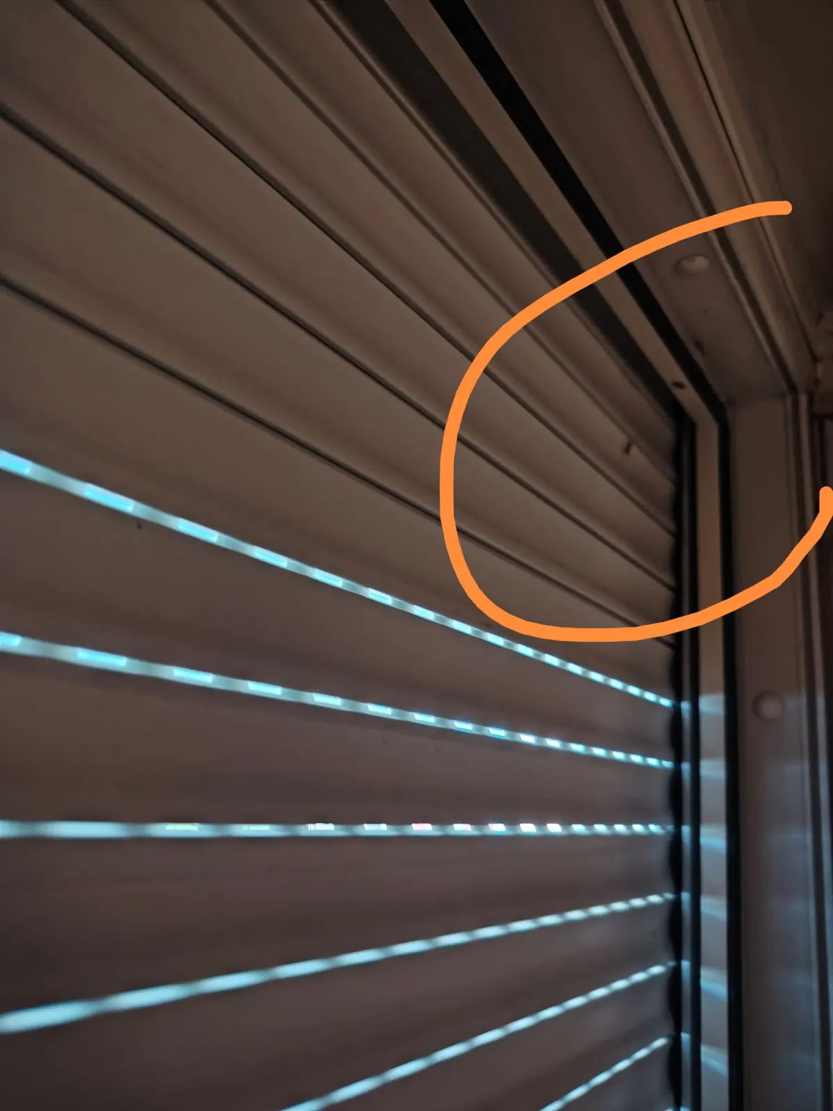 Photo envoyée par un client montrant l'entrée d'un nid de guêpes dans un volet roulant